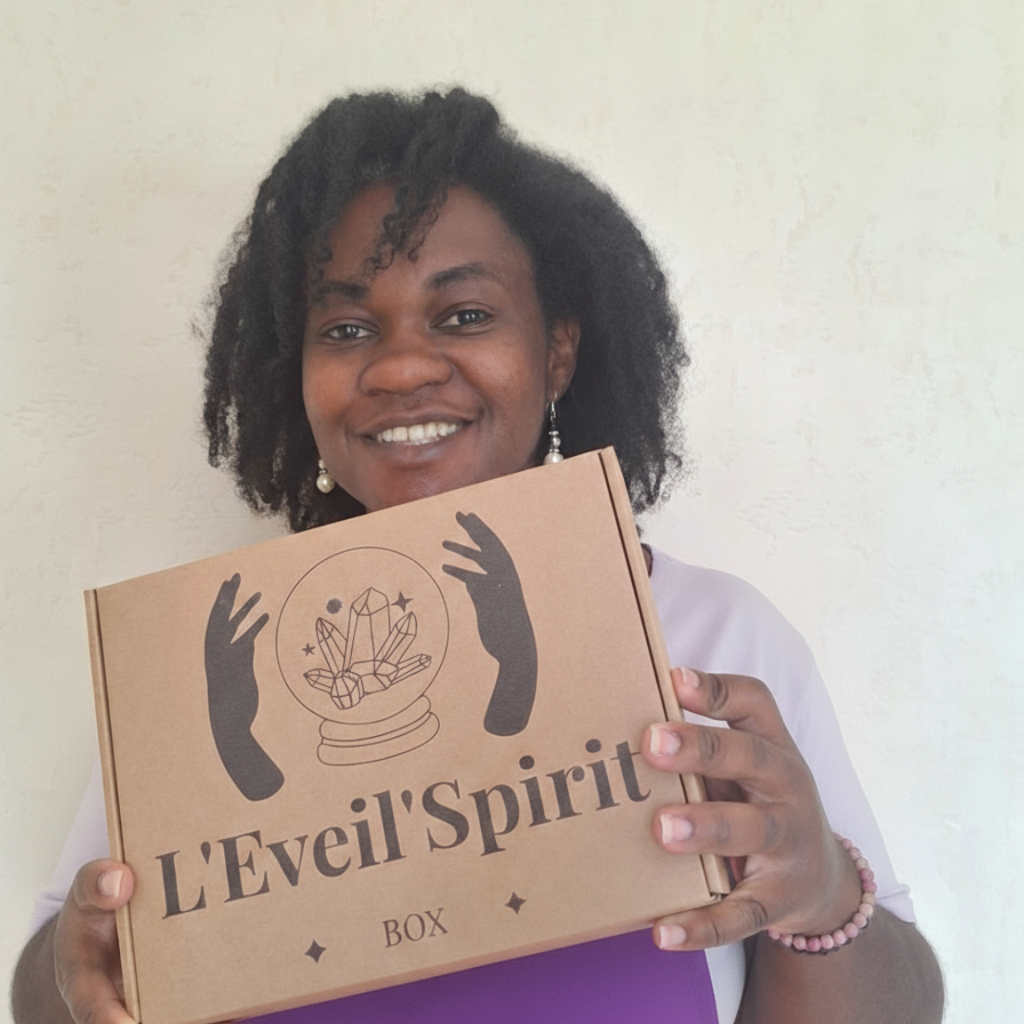 Personne tenant la box spirituelle leveilspiritbox devant un mur clair.